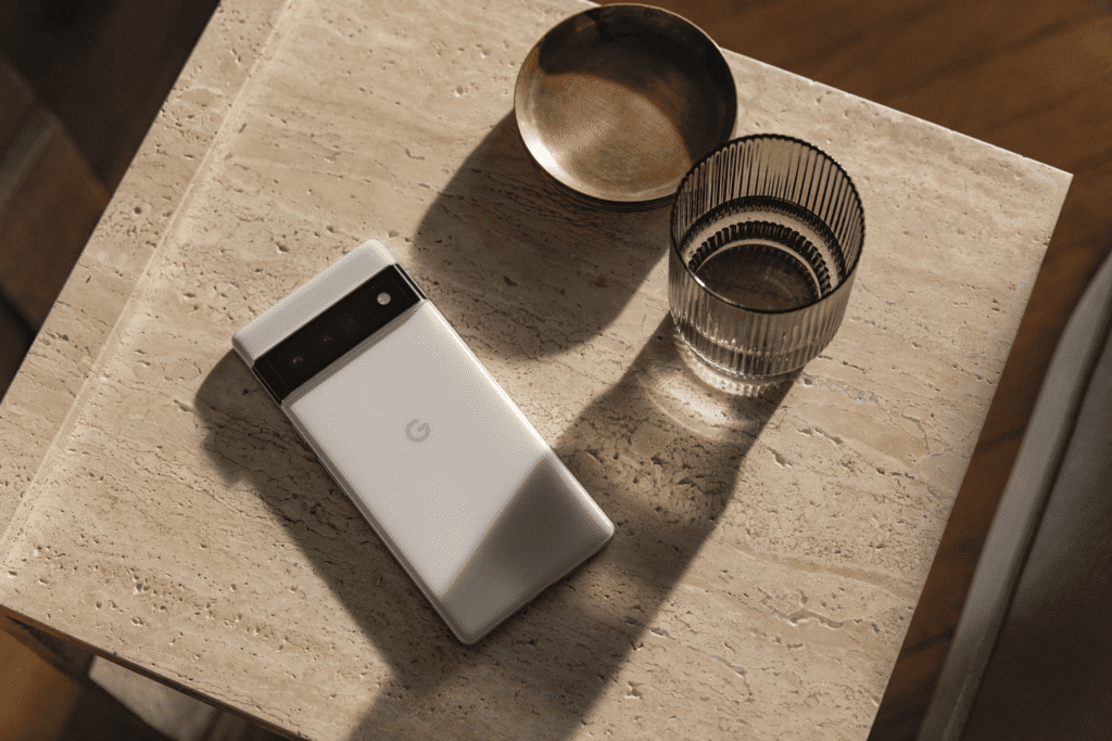 Google Pixel 6 Pro su un tavolo di pietra con un bicchiere d'acqua