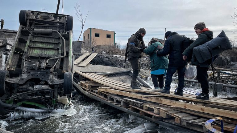 Le famiglie evacuate da Irvine attraversano un ponte distrutto