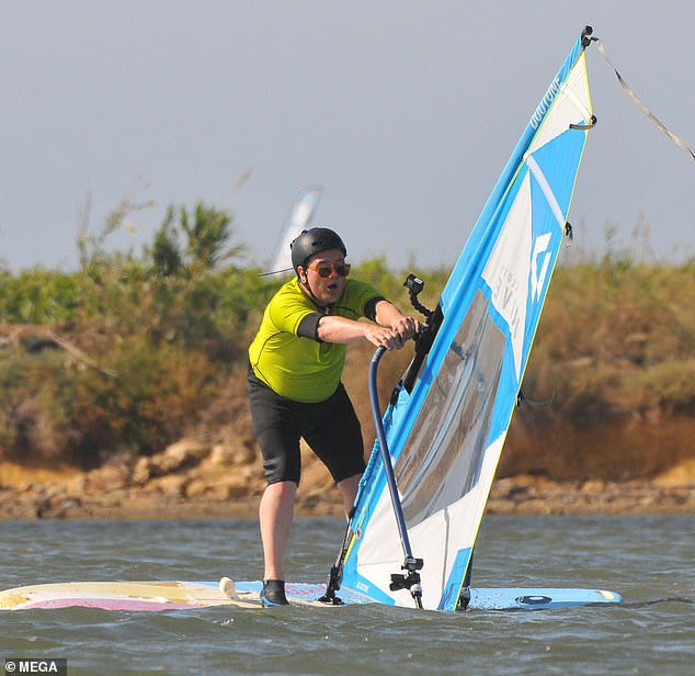 alla cautela!  Alan Carr, 45 anni, ha indossato la sua muta per provare il windsurf durante le riprese del suo nuovo spettacolo in Sicilia mercoledì.