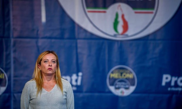 Giorgia Meloni fa campagna elettorale ad Ancora, in Italia, con il logo luminoso del suo partito, che condivide con un partito neofascista, dietro di lei.